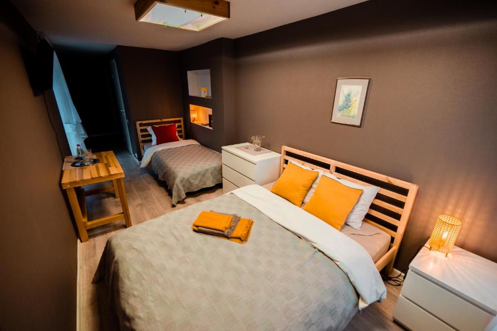 a bedroom with two beds with orange pillows at Viesu māja Stadula in Skrunda