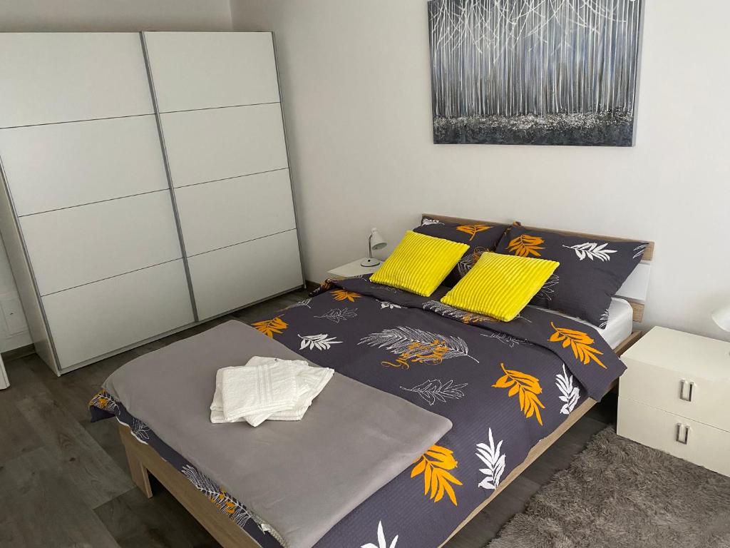 a bedroom with a bed with yellow pillows at ASTORIA in Varaždin