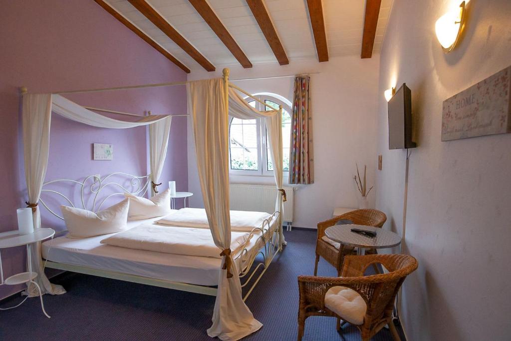 a bedroom with a canopy bed and a window at Hotel Dolgesheim in Dolgesheim
