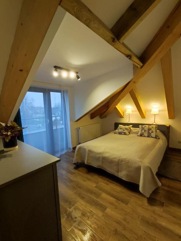 1 dormitorio con 1 cama grande en el ático en Aquarius Stawy 10, en Grodzisk Mazowiecki
