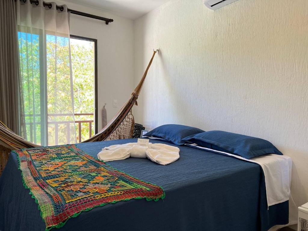 a bedroom with a bed with blue sheets and a hammock at Pousada do lago in Guaramiranga