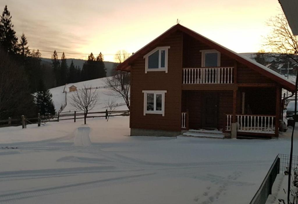a house with snow in front of it at Приватна садиба "Гірський затишок" in Vorokhta