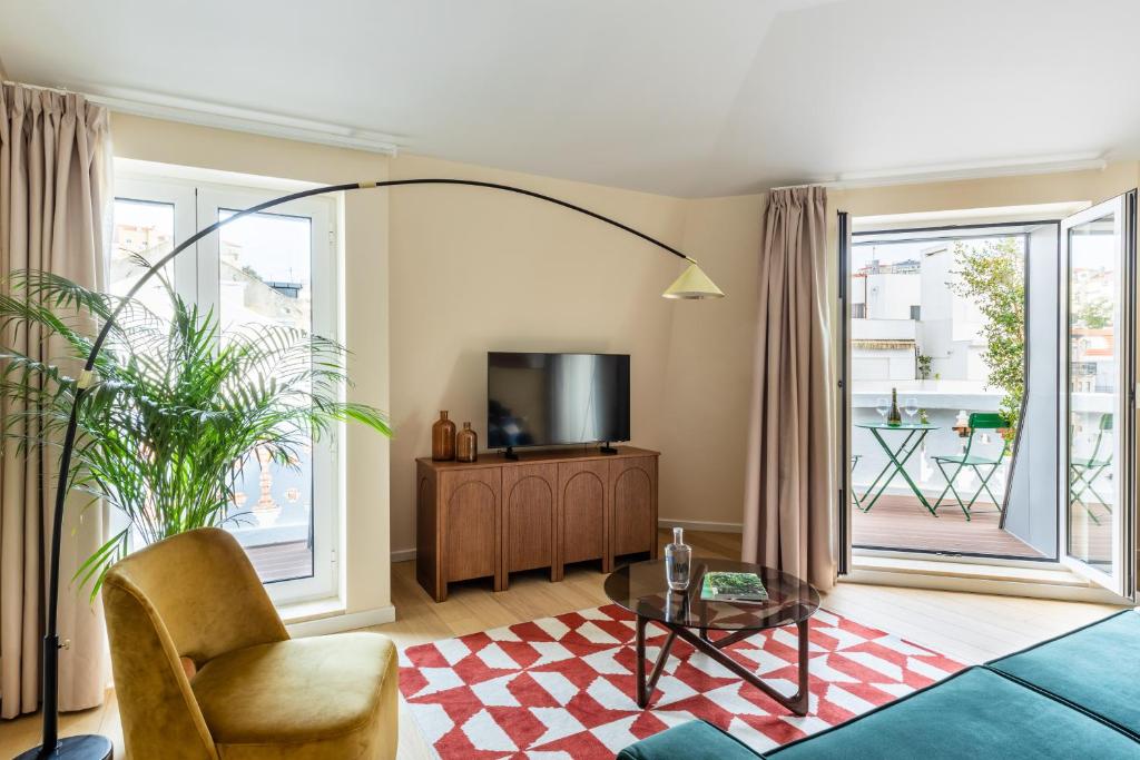A bright living room with television, lounge chair and balcony doors.