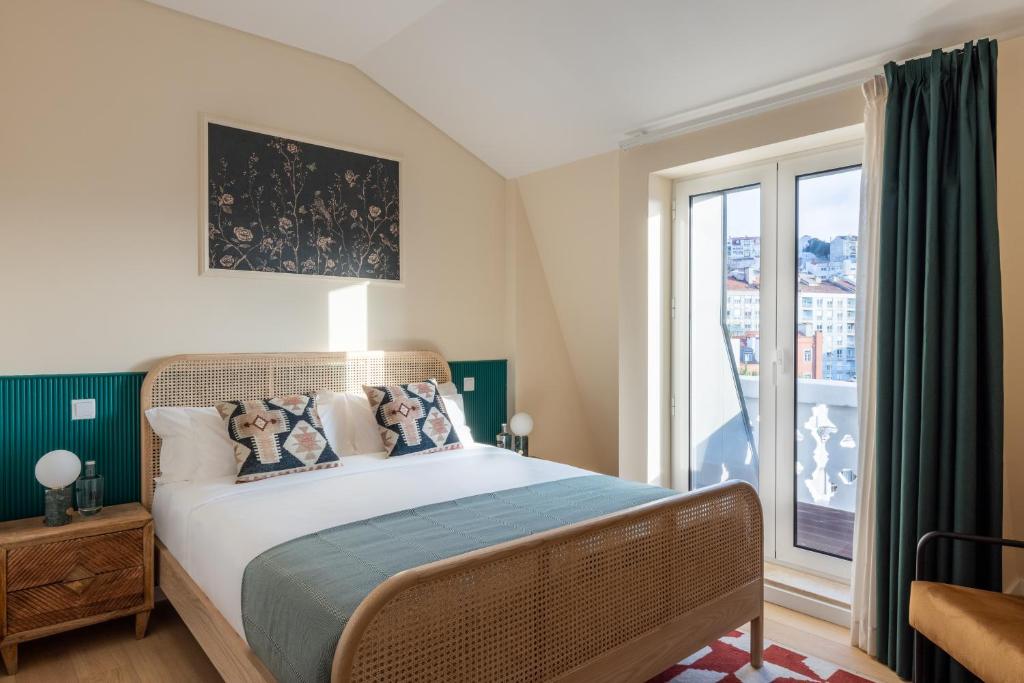 A double bedroom with a rattan bed frame and hillside city view.