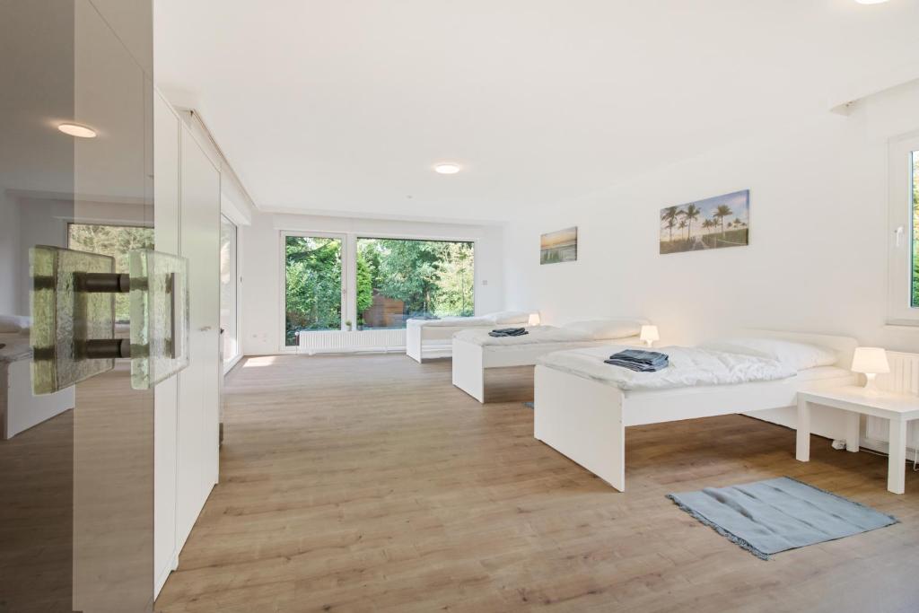 un salon blanc avec deux lits et un canapé dans l'établissement Stilvoller Bungalow in Selm-Cappenberg, à Selm