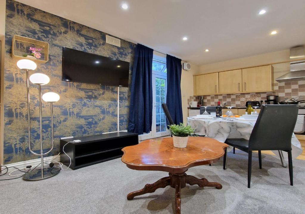 a living room with a table and a kitchen at The Kenilworth Spacious 2-bedroom w/ Free Parking by Sublime Stays in Spon End