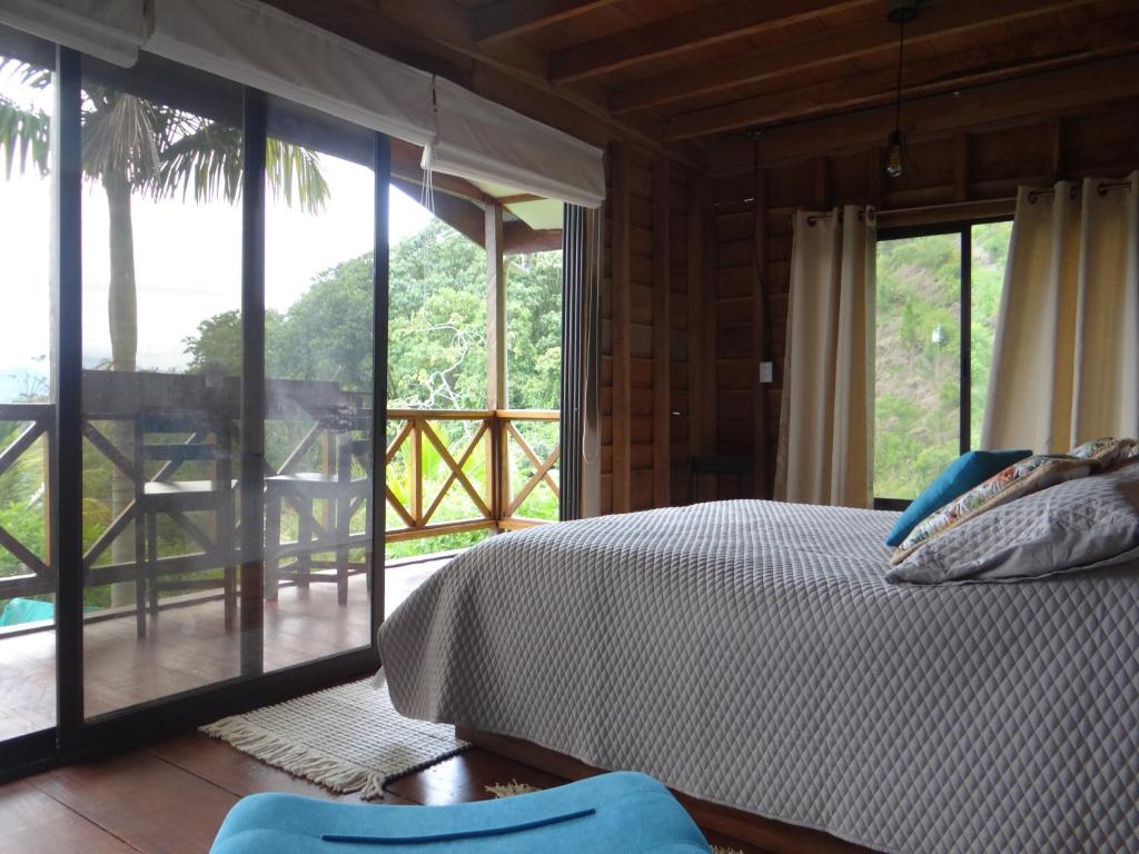um quarto com uma cama e portas de vidro deslizantes em Cabaña Tribu 