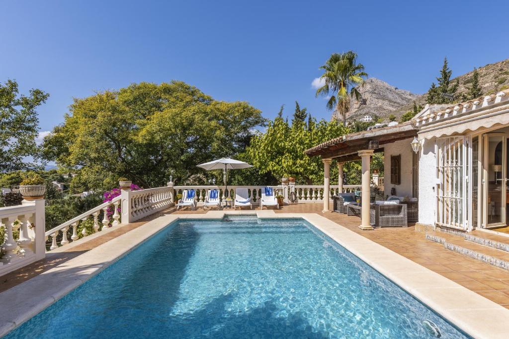 una piscina con terraza y una casa en Villa Levante, en Jávea