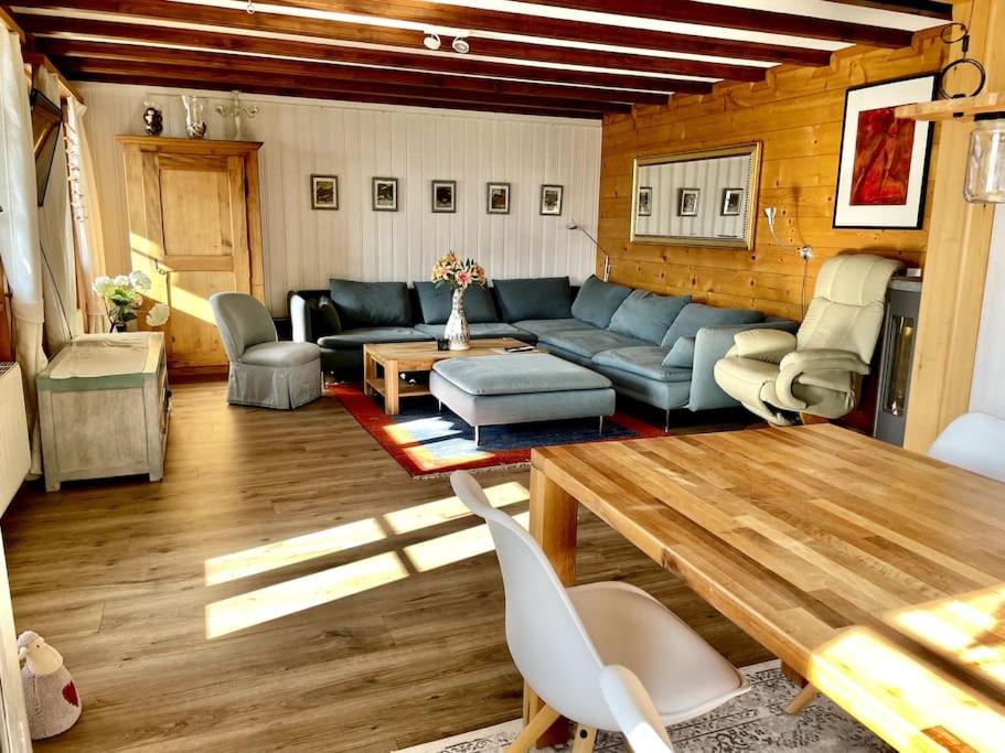 a living room with a blue couch and a table at Chalet an sonniger aussichtsreicher Lage in Mund
