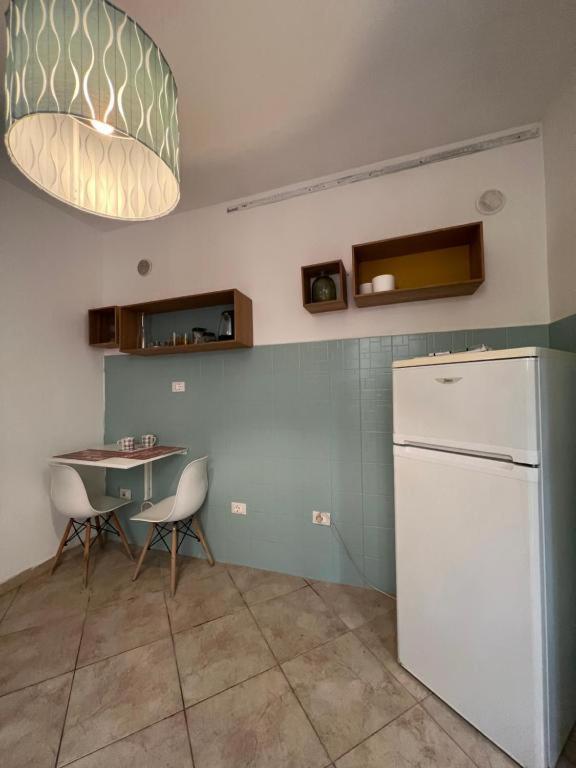 eine Küche mit einem Tisch und einem weißen Kühlschrank in der Unterkunft Pardus Domus HOWME in Bari