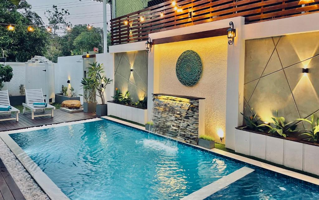 a swimming pool in a backyard with a fireplace at 8 Plus Motels in Negombo