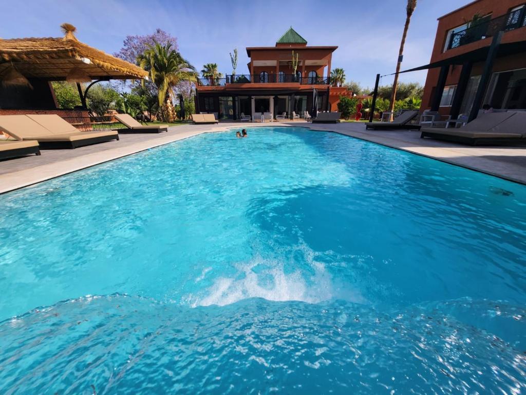 a large blue swimming pool with a building in the background at Domaine K Marrakech in Marrakesh