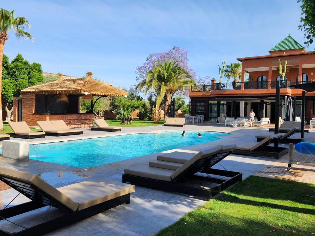 マラケシュにあるDomaine K Marrakechのラウンジチェア付きのスイミングプール、家
