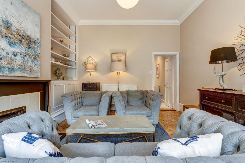 ein Wohnzimmer mit Sofas und einem Tisch in der Unterkunft Rawlinson Road 10A in Oxford