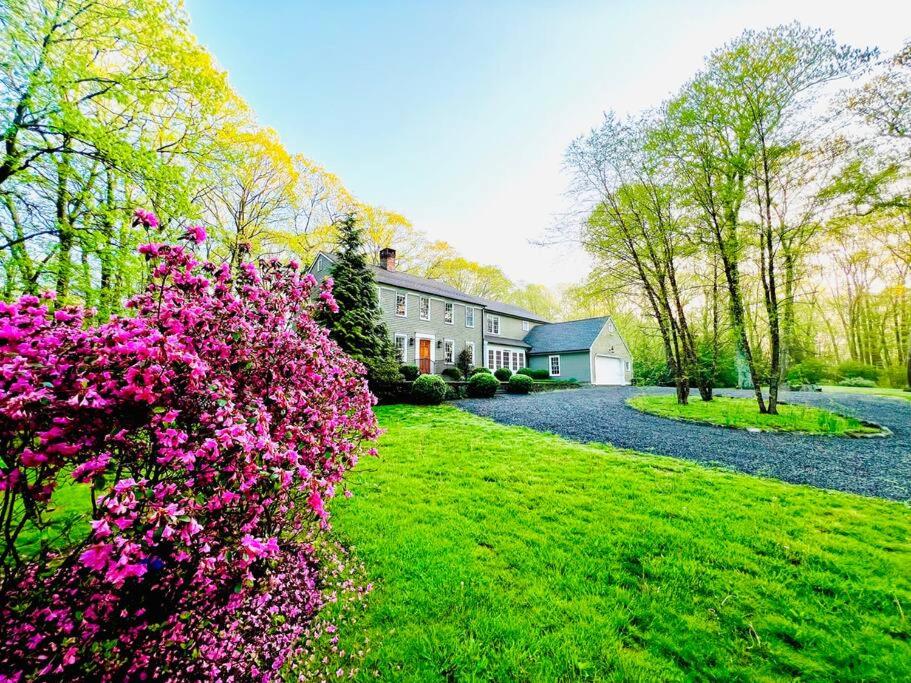 a house with pink flowers in front of a yard at Upmarket Country Retreat, Washington, Connecticut in Washington