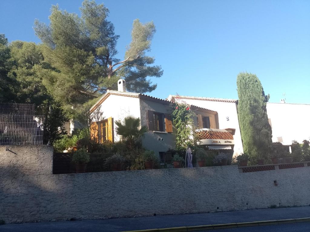 une maison blanche avec des arbres et une clôture dans l'établissement Villa les Cigales a la Madrague, à Saint-Cyr-sur-Mer