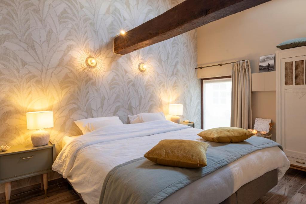 a bedroom with a large bed with two pillows on it at La Bergerie in Leuze-en-Hainaut