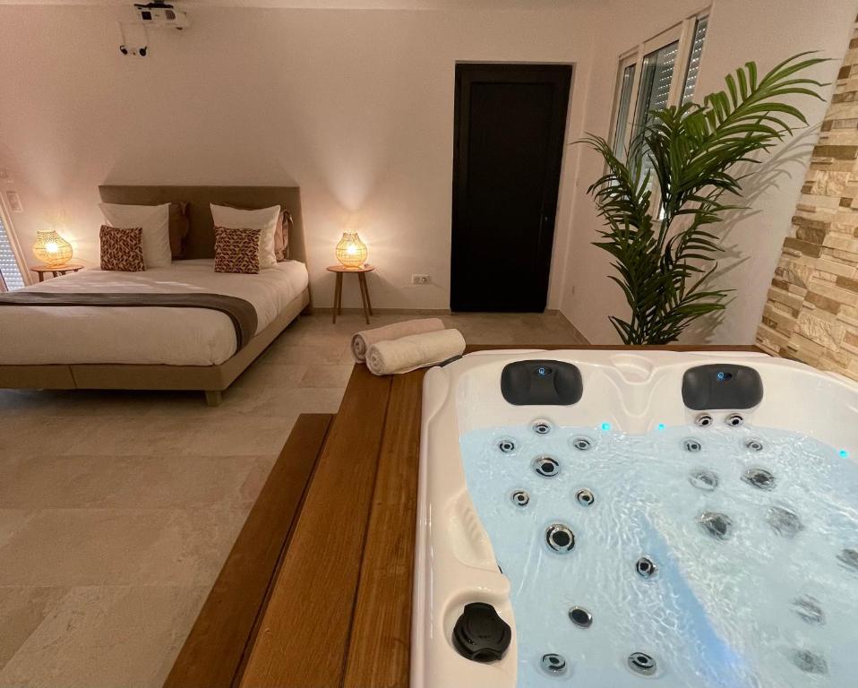 bañera en una habitación con cama en Baya Spa en Les-Pennes-Mirabeau