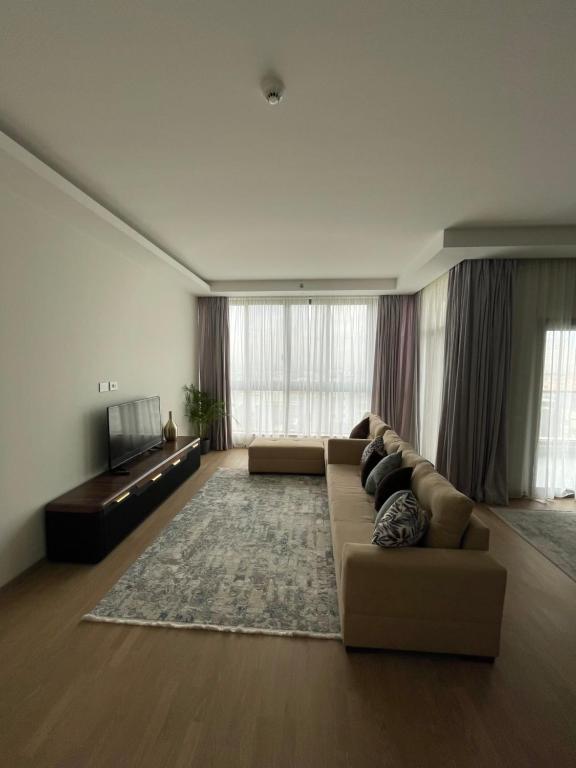 a large living room with a couch and a television at Premium hotel apartment Aeon towers Sheikh Zayed City in 6th Of October