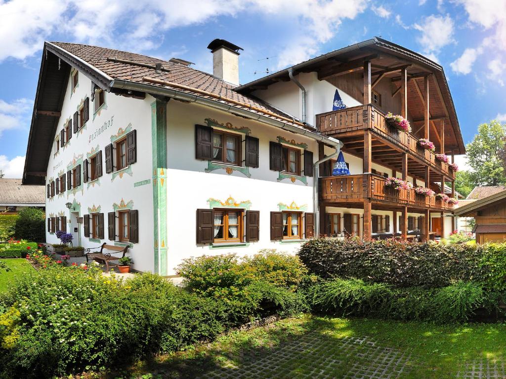 ein großes weißes Gebäude mit Balkon in der Unterkunft Gästehaus Enzianhof Hotel Garni in Oberammergau