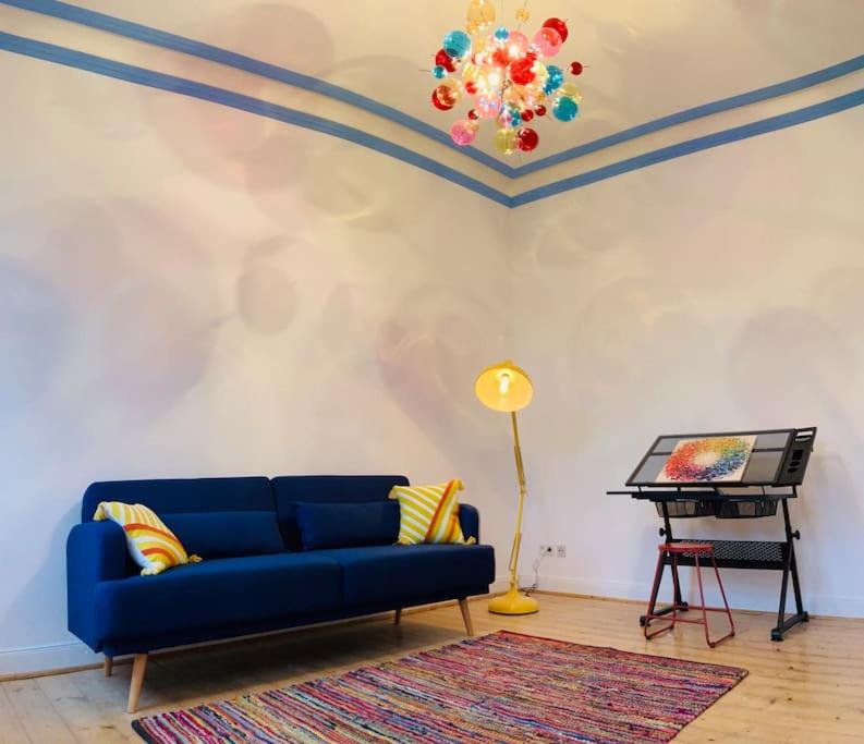 sala de estar con sofá azul y piano en SECRET HIDEAWAYS Design Apartment ARTstudio 5 nahe City l Messe l Hbf, en Duisburg