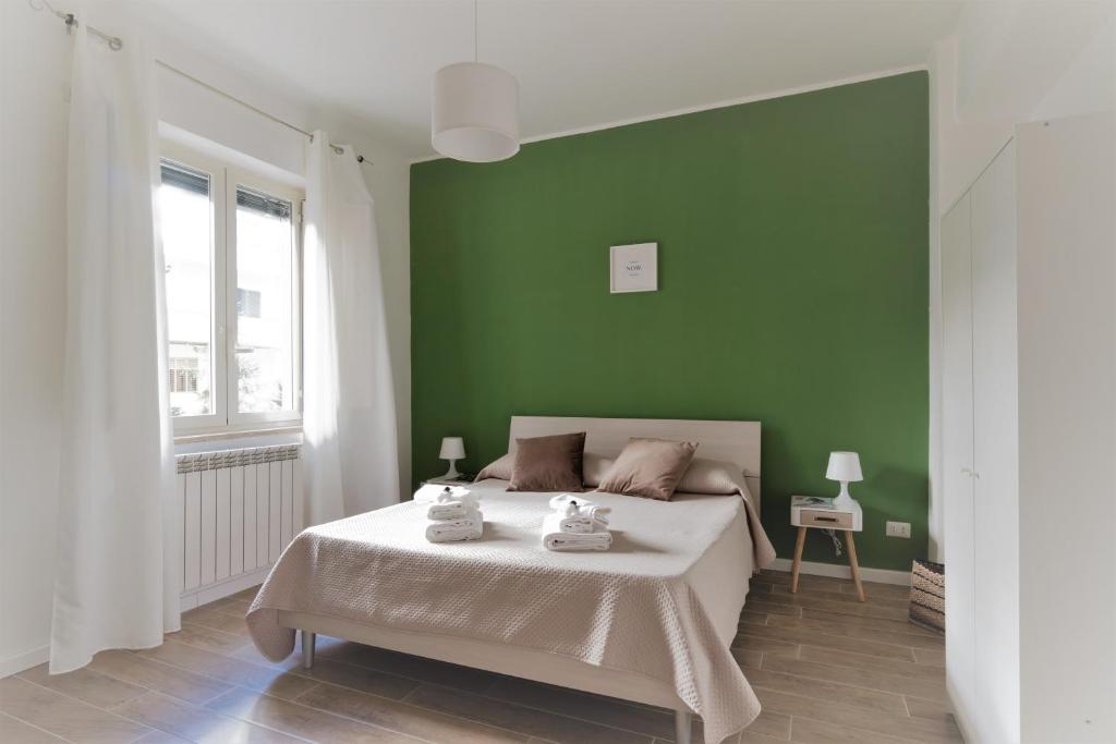 een groene slaapkamer met een bed en een groene muur bij Merylì House in Napels