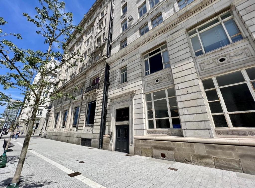 a large stone building on a city street at Liverpool Waterfront Apartment in Liverpool