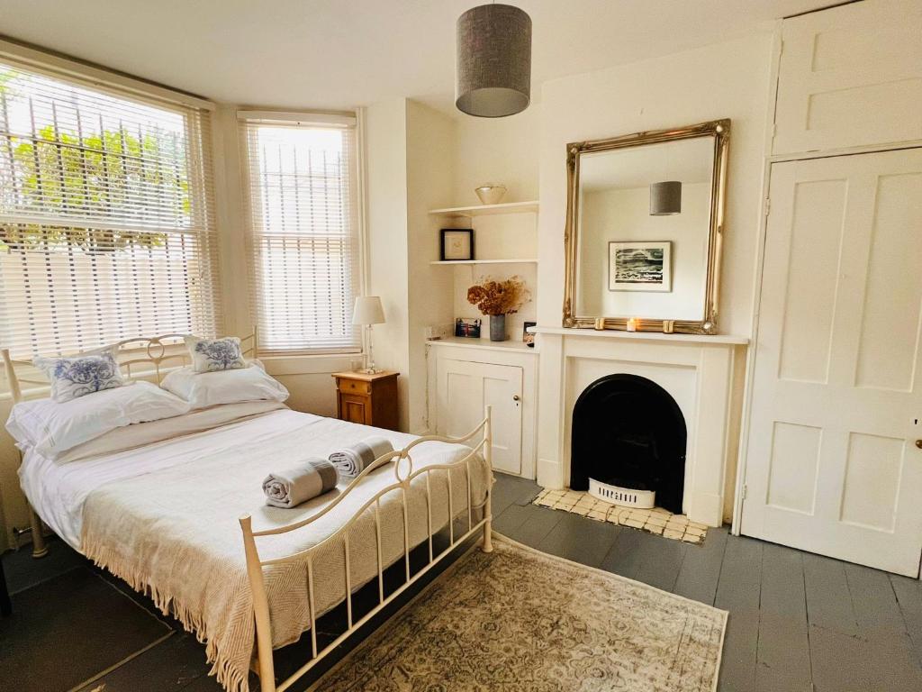 een slaapkamer met een bed met een spiegel en een open haard bij Pretty studio, 2 minutes to beach! Self-contained. in Brighton & Hove