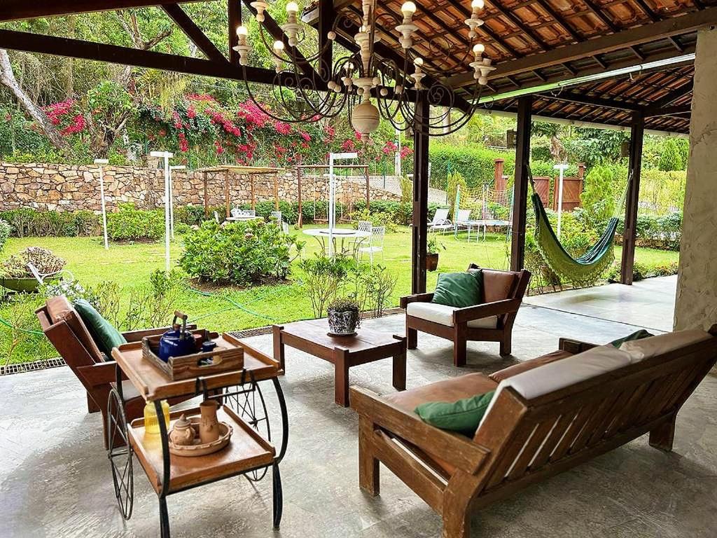 un patio con sillas, un sofá y una mesa en Pousada Monte Flor Guaramiranga CE en Guaramiranga