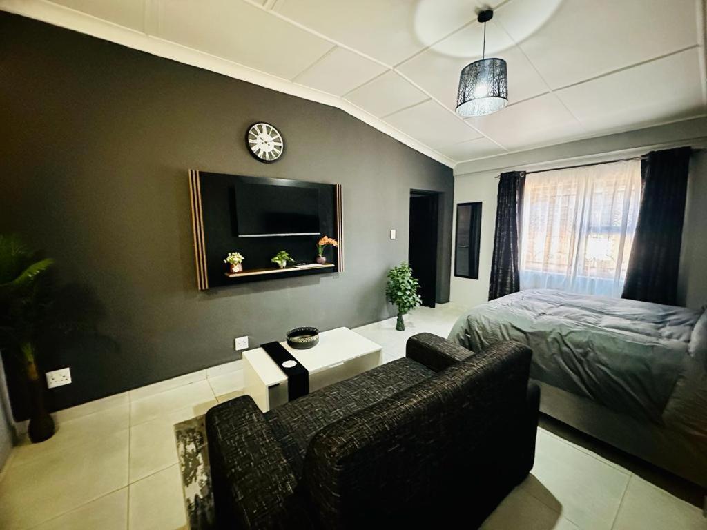 una camera con letto, divano e sedia di The Curve Apartments Unit 16 a Johannesburg