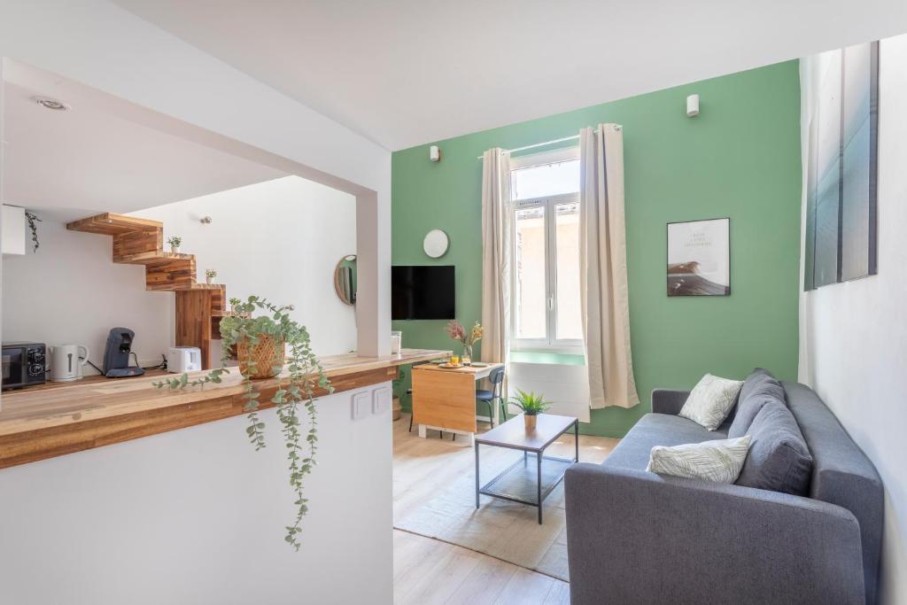 uma sala de estar com paredes verdes e um sofá em Duplex lumineux centre ville em Aix-en-Provence