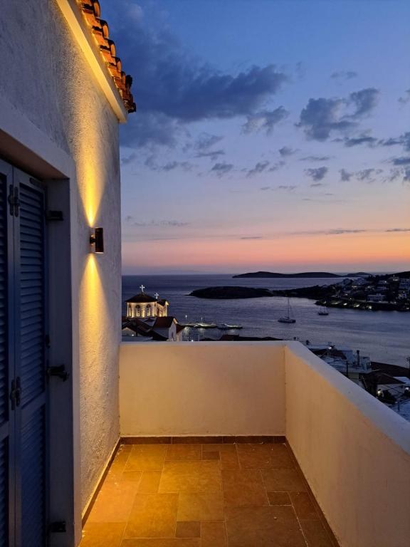 a balcony with a view of the ocean at sunset at Andros Villa in Andros