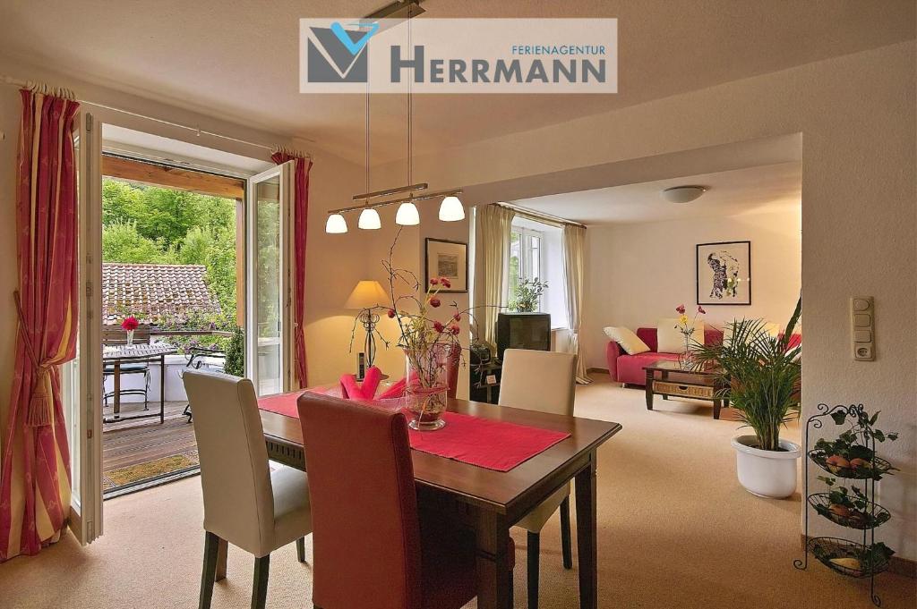 a dining room and living room with a table and chairs at Ferienwohnung Seidelbast in Füssen