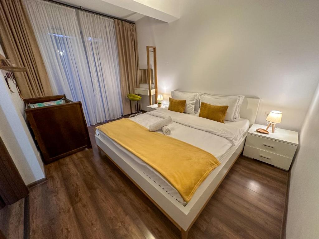 um quarto com uma cama grande e um cobertor amarelo em Holiday Apartment em Ghimbav