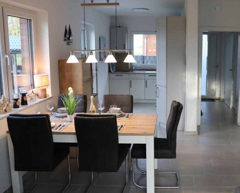 a dining room and kitchen with a table and chairs at Ferienhaus Dorie in Dornumersiel