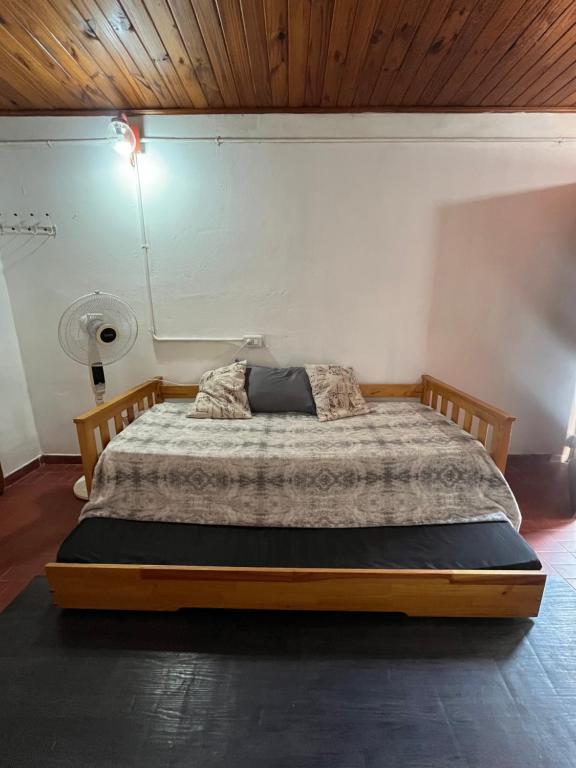 Bett in einem Schlafzimmer mit Holzdecke in der Unterkunft Monoambiente F en Ctes Cap in Corrientes