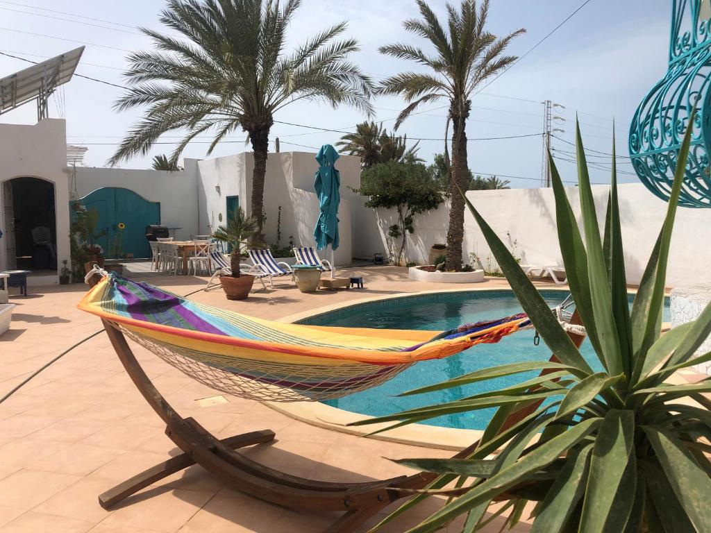 a hammock sitting on a patio next to a pool at aaa in Al Ḩaddādah