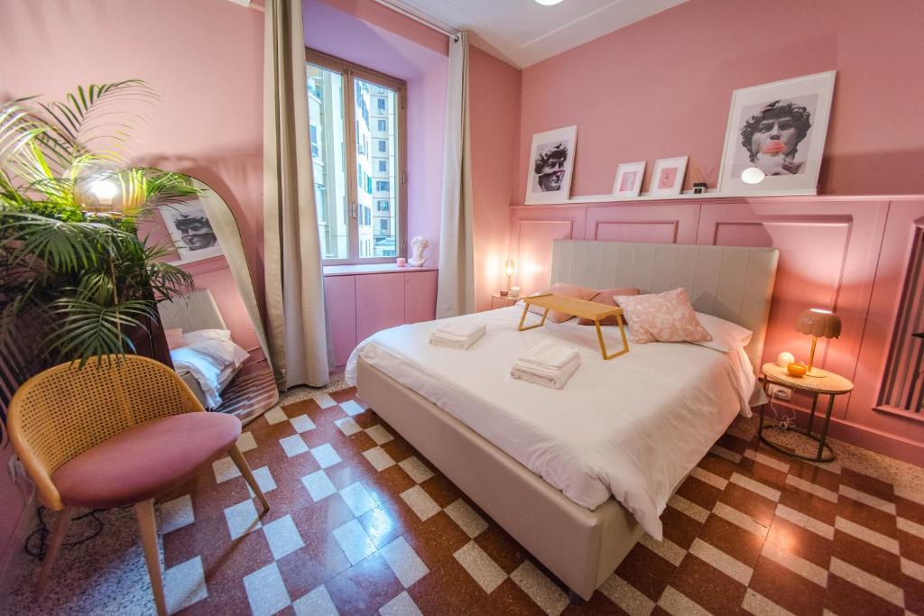ローマにあるDomus Febo-Telesio Suiteのピンクのベッドルーム(ベッド1台、椅子付)