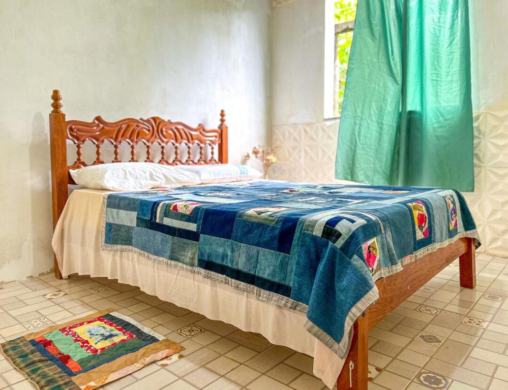 a bedroom with a bed with a blue and white blanket at Otima casa proxima a praia do Acuipe em Ilheus BA in Ilhéus