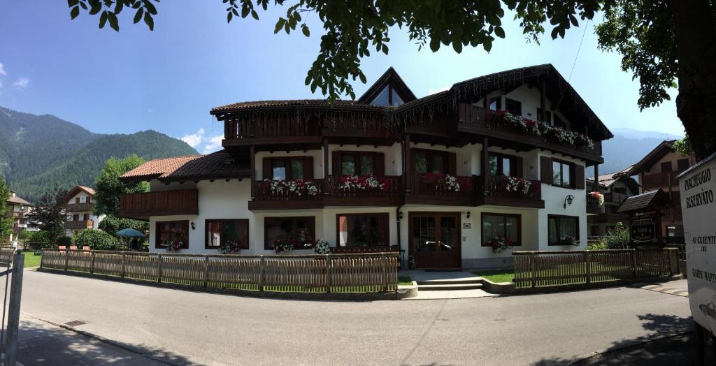 ein großes Haus mit Balkon auf einer Straße in der Unterkunft Albergo Garni Martina in Carisolo