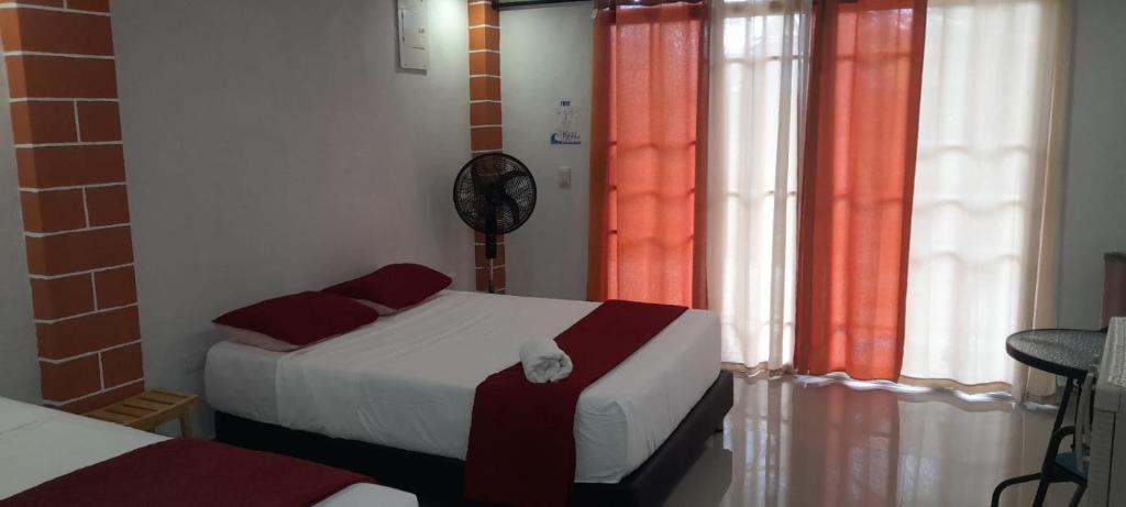 a bedroom with two beds and a clock on the wall at POSADA HIGH TIDE in San Andrés