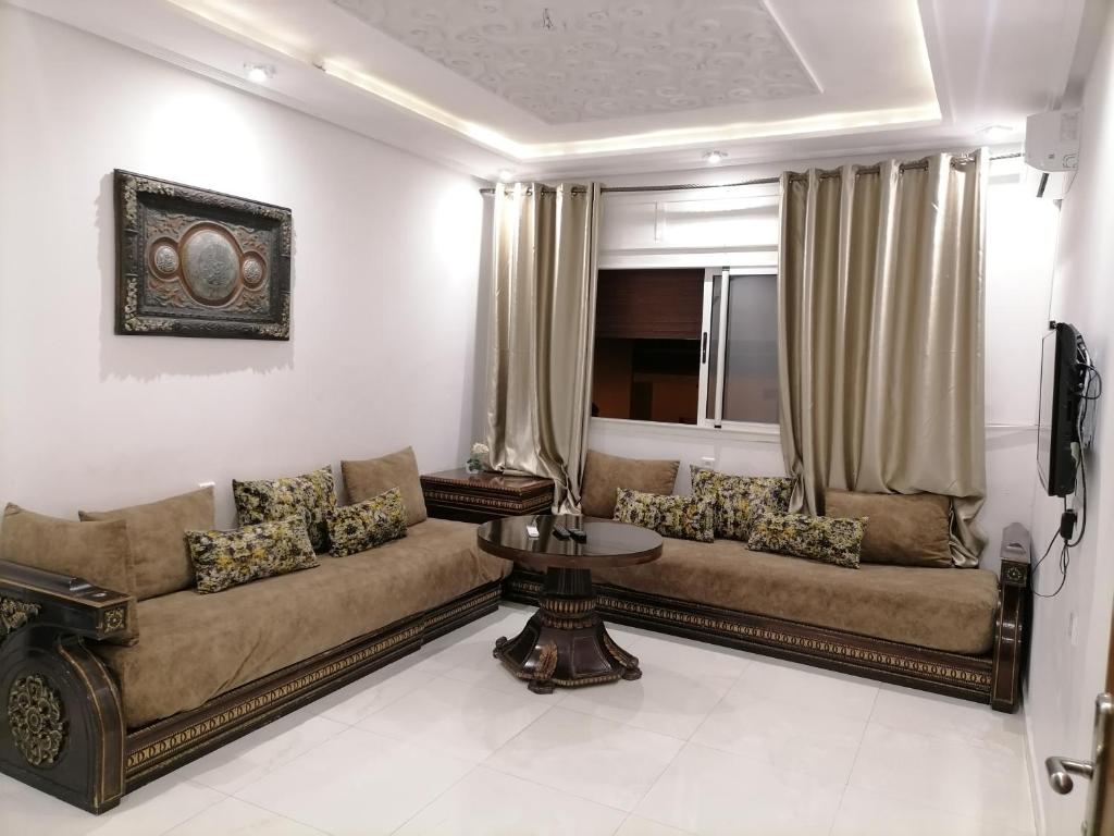 a living room with a couch and a table at Furnished apartments Family only in Tangier