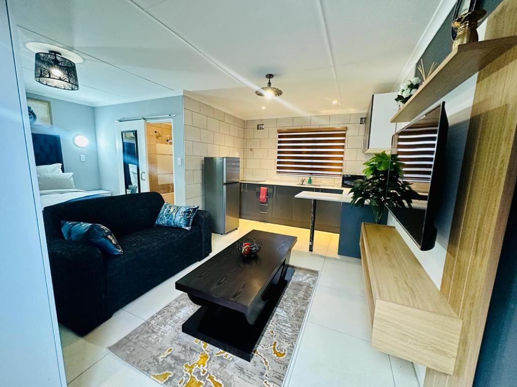 un soggiorno con divano e tavolo di The Curve Apartments Unit 15 a Johannesburg