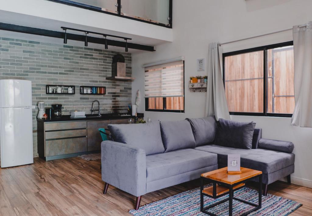 ein Wohnzimmer mit Sofa und eine Küche in der Unterkunft Peace Lofts and Apartments in Playa Santa Teresa