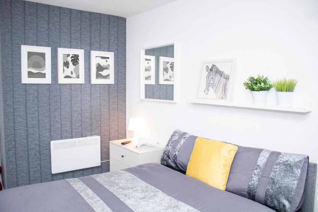 a bedroom with a bed and pictures on the wall at Chill Nexus Oasis in Liverpool
