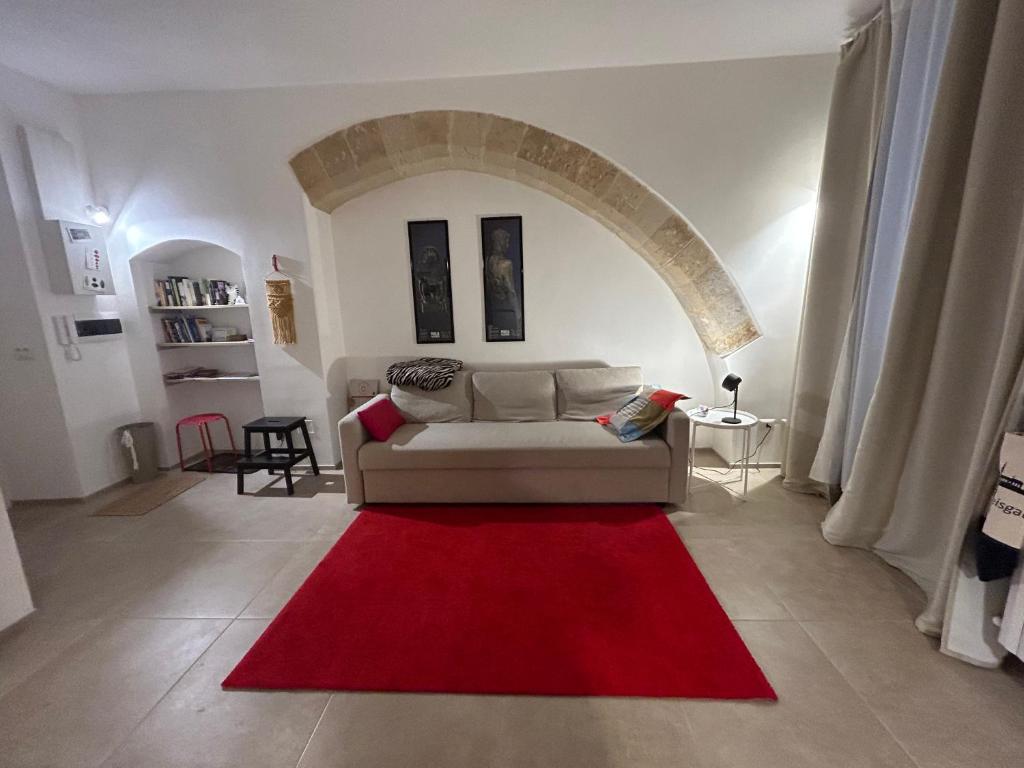 - un salon avec un canapé et un tapis rouge dans l'établissement CASA STORTA 34, à Lecce
