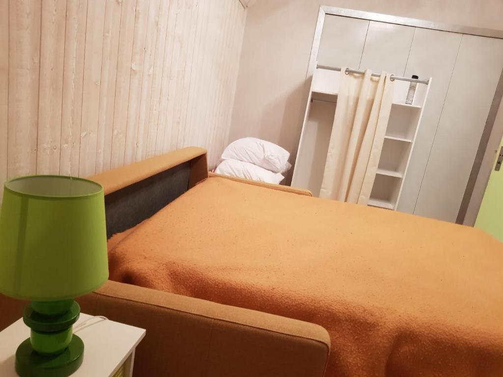 een slaapkamer met een bed met een groene lamp en een spiegel bij pinson 