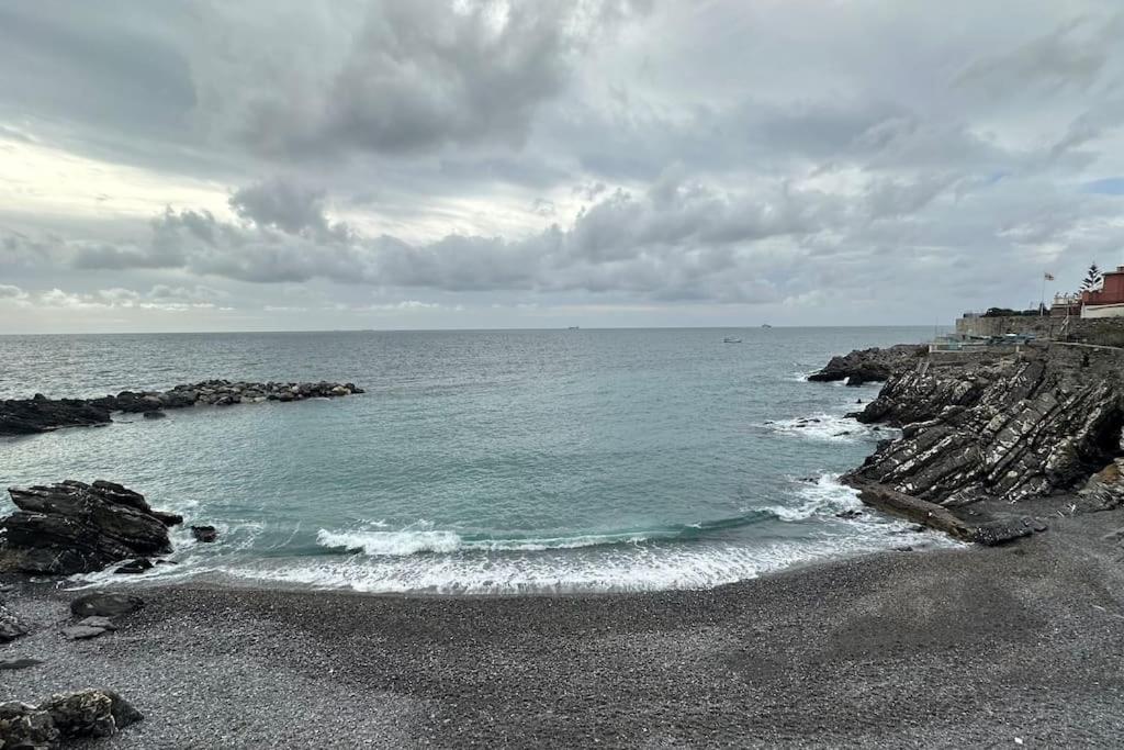 a beach with a rocky shoreline and the ocean at MaMi a 2 passi dal mare in Genoa