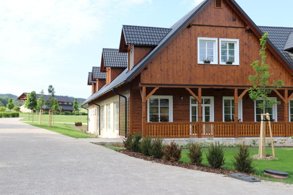 uma casa de madeira com um telhado de gambrel em Hotel U Pekaře - Jítravský Dvorec em Rynoltice