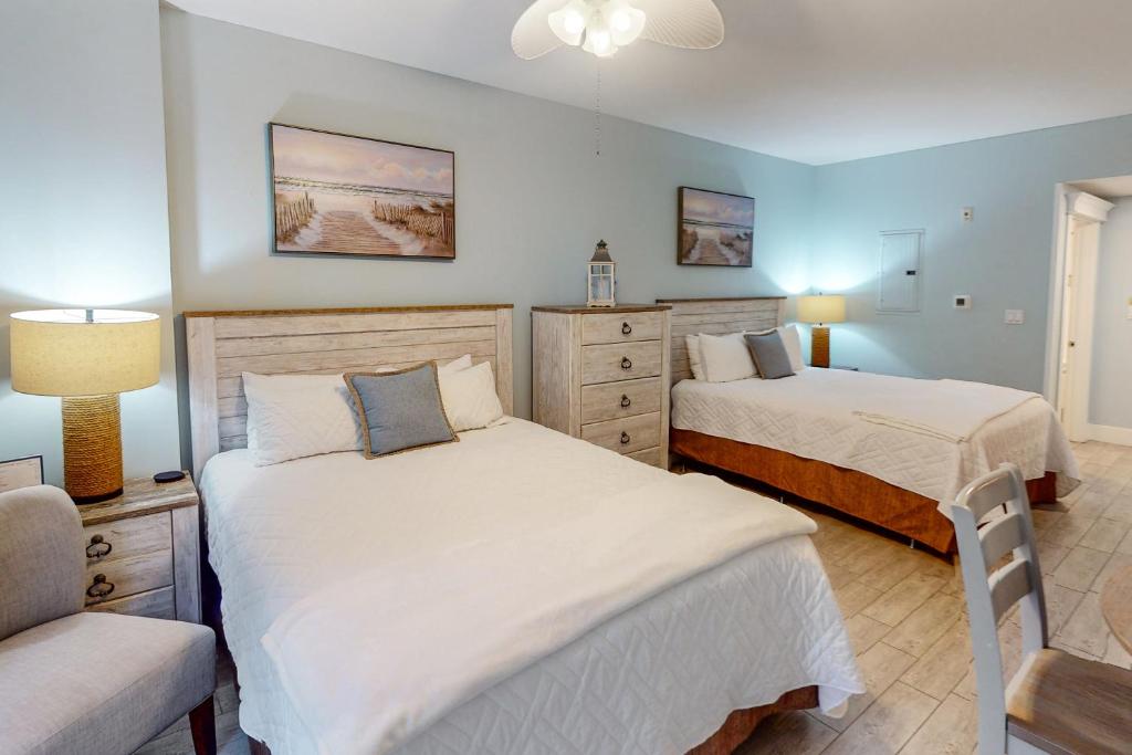 a bedroom with two beds and a chair at Lasata 3204 in Destin